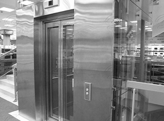 Примыкание стеклянных панелей к лифтовому порталу из нержавеющей стали